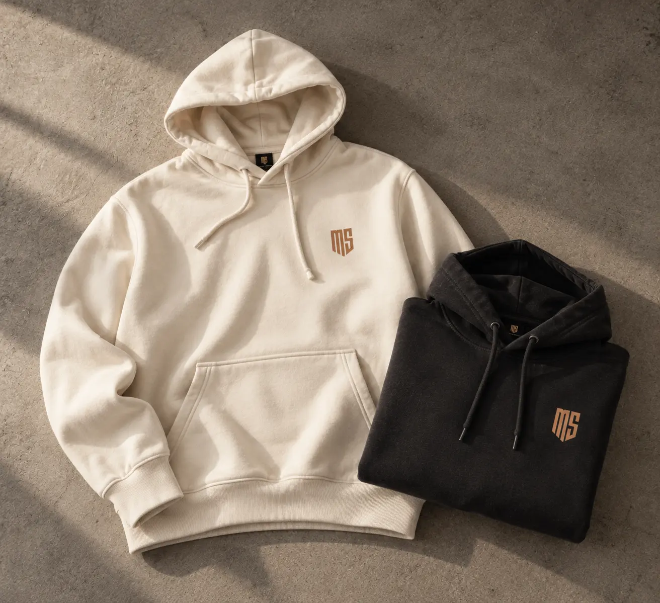 Premium hoodies i off-white och svart med broderad Merch Studio-logotyp